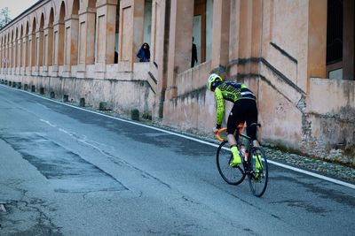 Rear view of man cycling on street