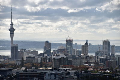 Buildings in city against cloudy sky