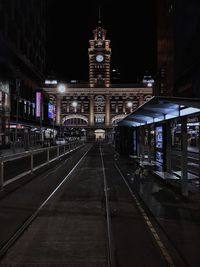 Illuminated railroad station platform at night