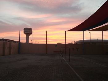 Empty road against sky at sunset