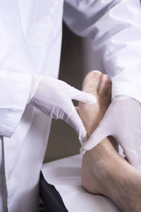 Midsection of doctor examining leg