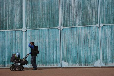 Side view of man cycling against wall