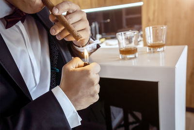 Midsection of businessman holding wineglass