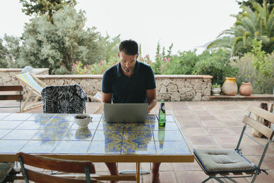 Man using laptop on patio