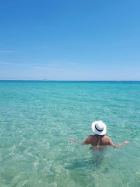 Man in sea against sky