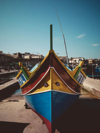 Ship moored on beach against clear blue sky