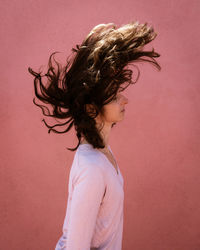 Portrait of woman against red background