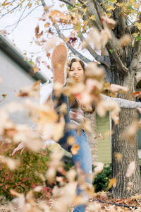 Happy young girl playing with autumn leaves 