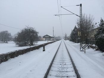 Snow covered railroad tracks against sky