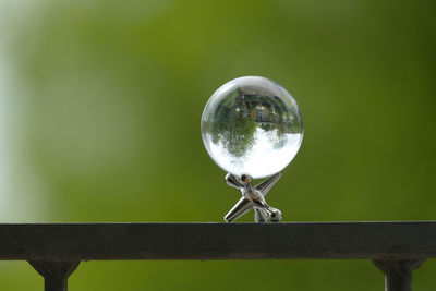 Close-up of crystal ball on metal railing