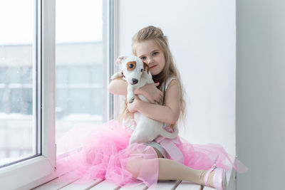 Portrait of woman with dog sitting at home