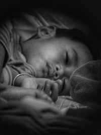 Close-up of baby sleeping on bed