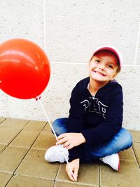 Portrait of happy boy playing with balloons