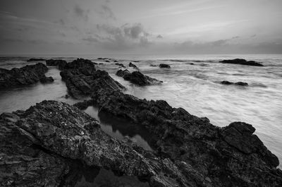 Rocks on beach against sky