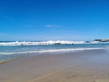 Scenic view of beach against blue sky