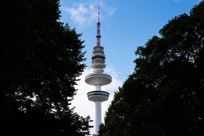 Low angle view of tower and trees against sky