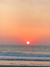 Scenic view of sea against orange sky