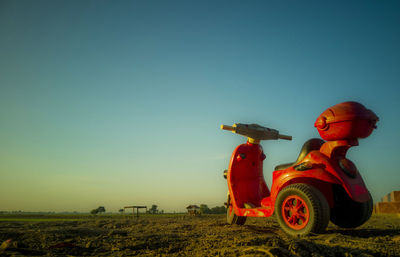 Stuffed toy on field against clear blue sky