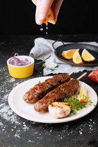 Fried sausages with the addition of herbs, vegetables, garlic, lemon and onions on the dish