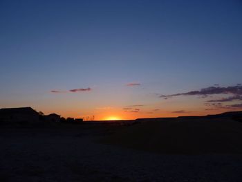 Scenic view of silhouette field against sky during sunset