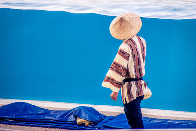 Rear view of woman standing by sea against sky