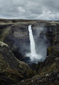 Scenic view of waterfall against sky