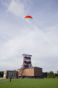 Mid distance view of man flying kite against sky