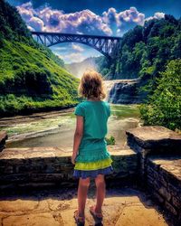 Rear view of boy standing on bridge