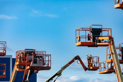 Low angle view of crane at construction site against sky