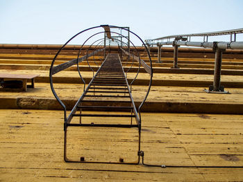 Metallic structure in playground against clear sky