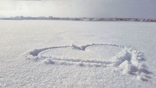 Close-up of frozen sea against sky during winter