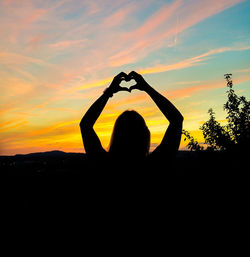 Silhouette person against sky during sunset