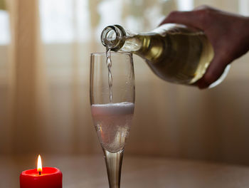 Close-up of hand pouring wine in glass