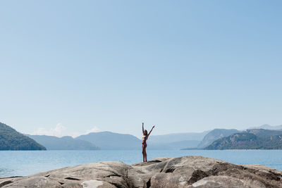 Man standing on beach against clear sky