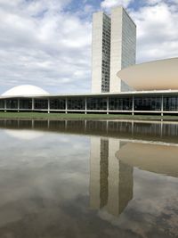 Reflection of building in lake against sky