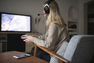 Young woman with headset playing video game