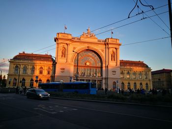 Cars on city street against clear sky