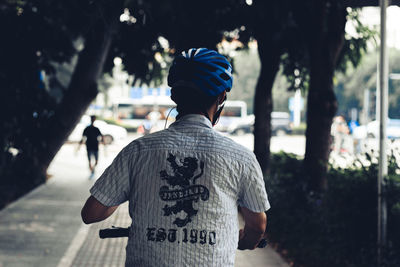 Rear view of men standing on street in city