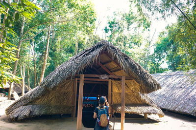 Rear view of people on hut in forest