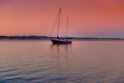 Sailboat sailing on sea against sky during sunset