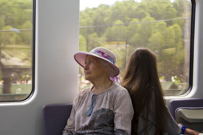 Woman sitting by window while traveling in train