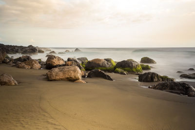 Rocks on beach against sky