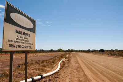 Road sign against clear sky