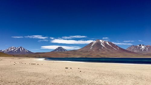 Scenic view of snowcapped mountains against blue sky