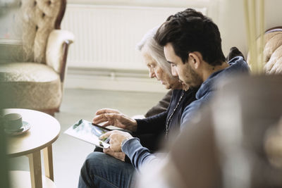 Caretaker and senior woman using digital tablet at nursing home