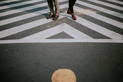 Low section of people walking on zebra crossing