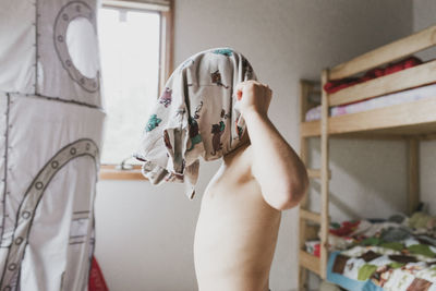 Side view of boy wearing t-shirt in bedroom at home