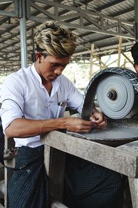 Man with grinder working at farm