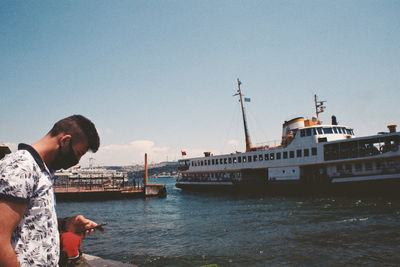 Side view of man standing in sea against clear sky