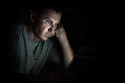 Close-up of thoughtful man in darkroom